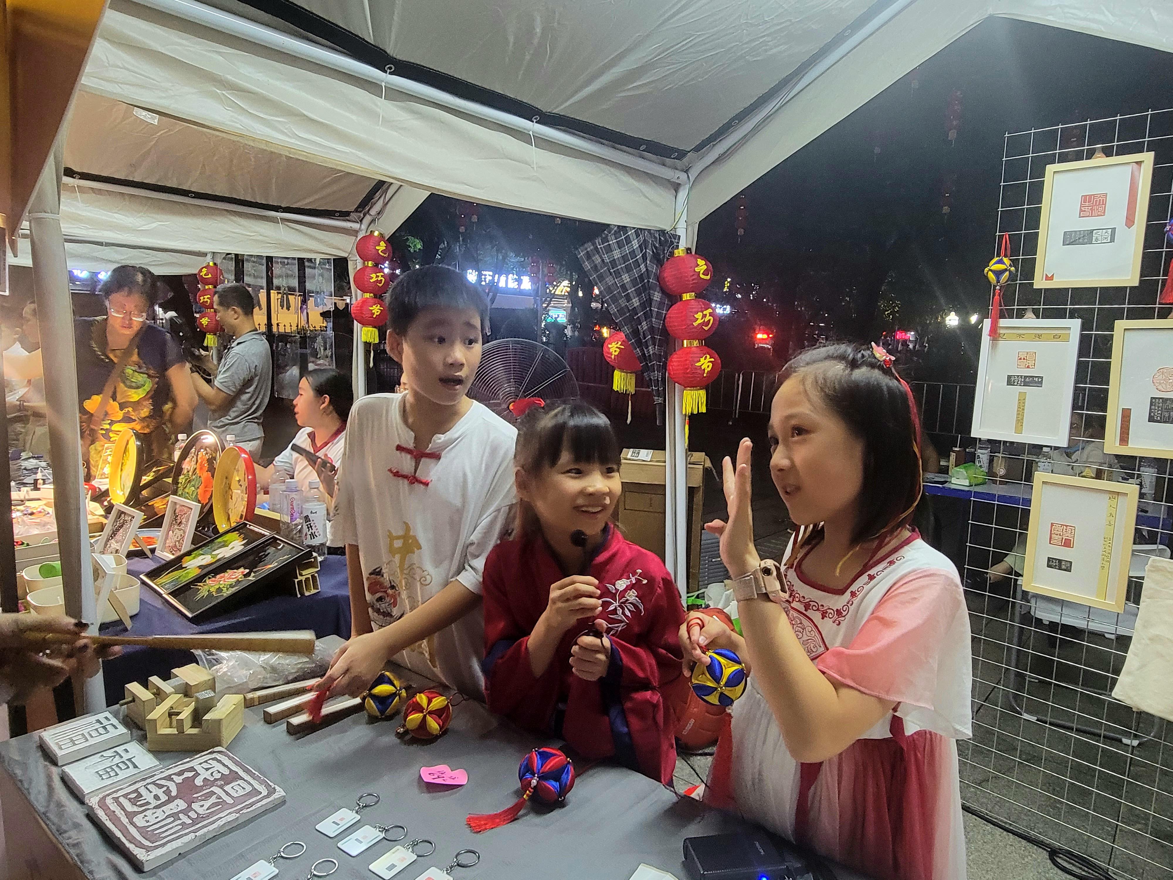 在非遺創(chuàng)意集市，廣州本地小學生向市民游客介紹師生制作的特色篆刻商品。人民網(wǎng) 寧玉瑛攝